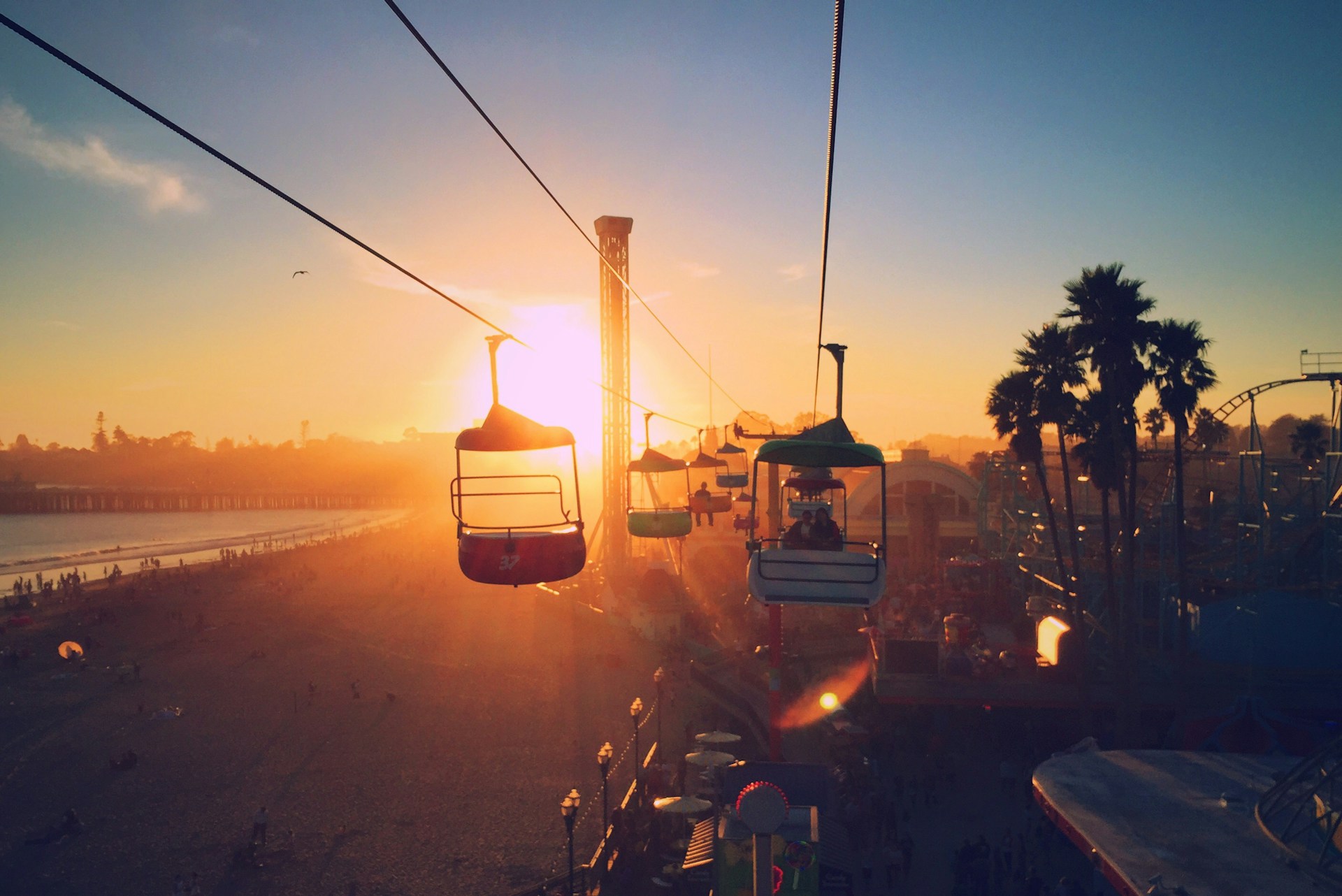 Sunset view of the Santa Cruz Beach Boardwalk with sky lift silhouetted against the golden sky